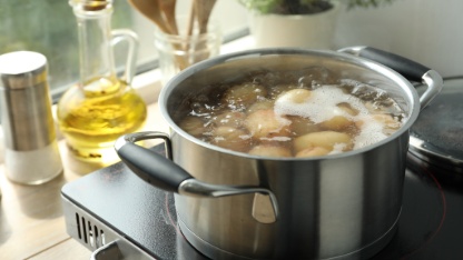 Boiling potatoes in pot on stove in kitchen
