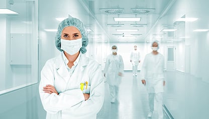 A woman in a lab coat standing in a hallway.